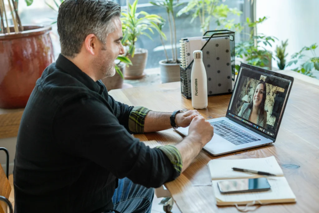 A man having a remote meeting with a coworker with a laptop