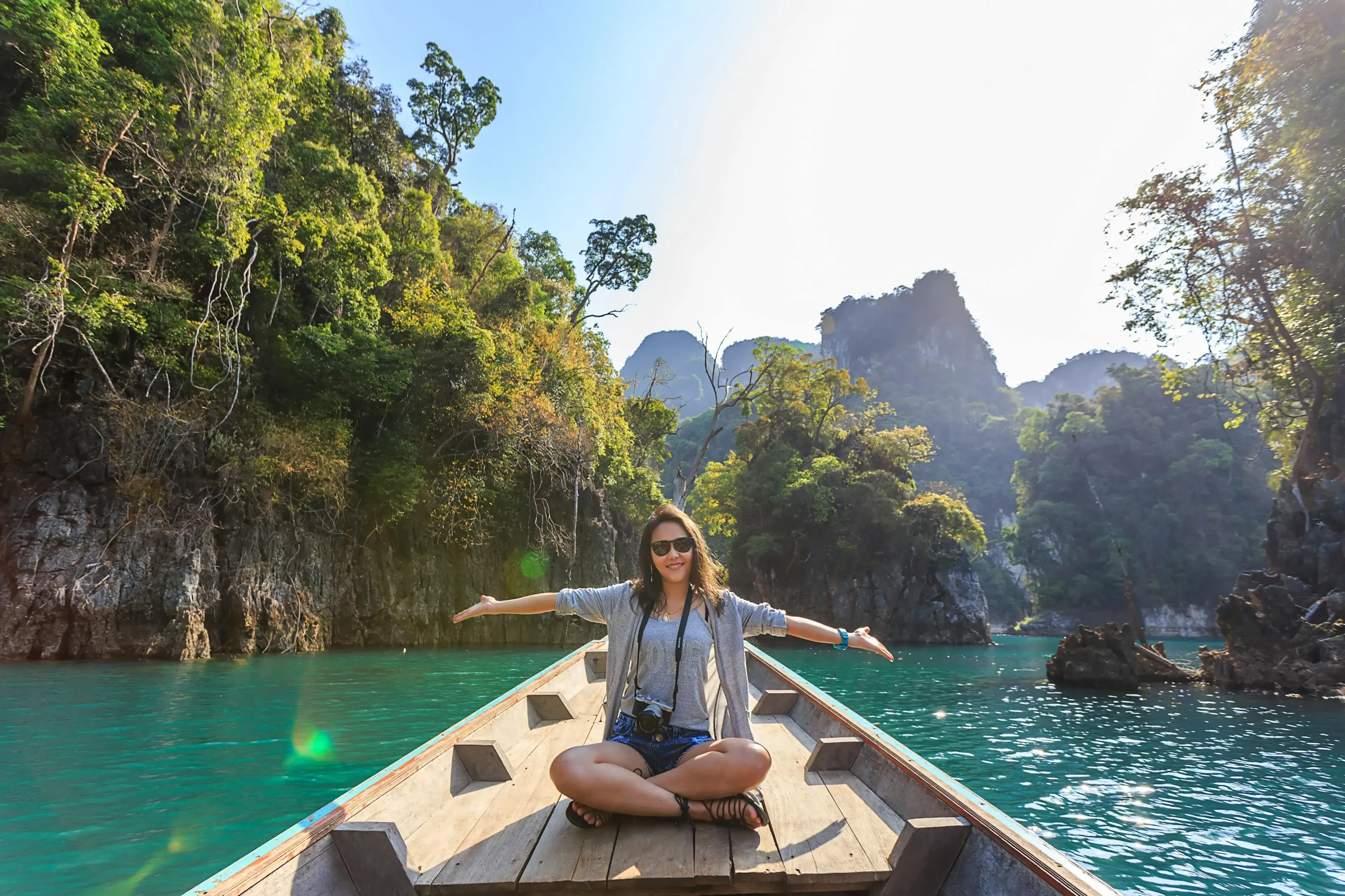 A photo of a smiling woman on a boat, surrounded by small islands